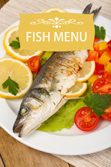 Delicious grilled fish on plate on table close-up