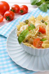 Delicious pasta with tomatoes on plate on table close-up