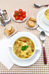 Tasty soup in saucepan on tablecloth, close up