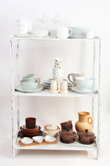 Different tableware on shelf, isolated on white
