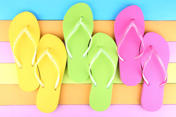 Bright flip-flops on color wooden background