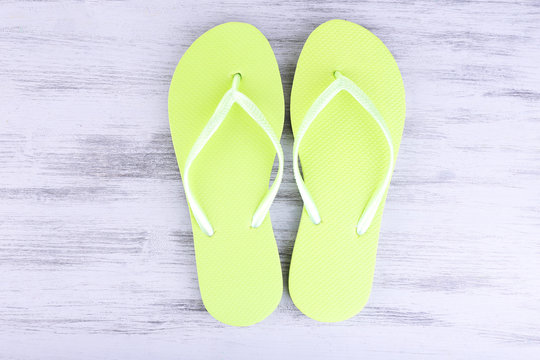 Bright flip-flops on color wooden background