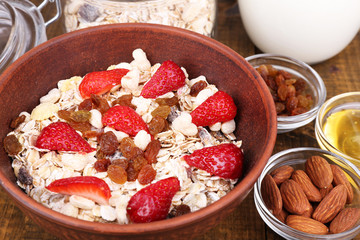 Healthy cereal with milk and strawberry on wooden table