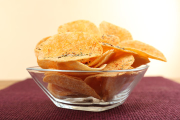 Homemade potato chips in glass bowl on table