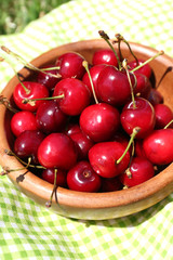 Sweet ripe cherries in wooden bowl,
