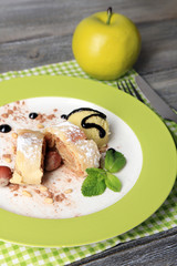 Tasty homemade apple strudel with nuts, mint leaves and