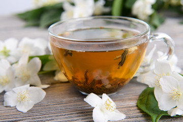 Cup of tea with jasmine on table close-up