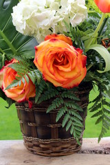 Fototapeta na wymiar Basket of flower, rose and hydrangea on a wooden board