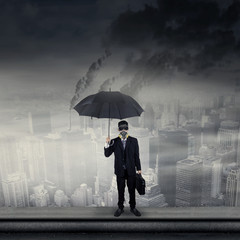 Businessman on rooftop wearing gas mask