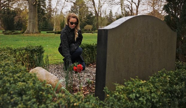 Young woman grieving at graveyard