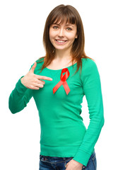 Woman is pointing to the red awareness ribbon