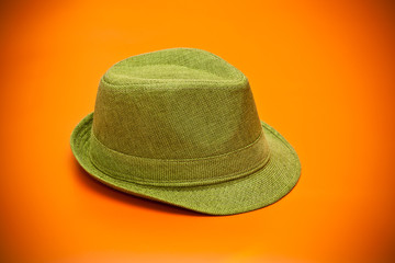modern green hat in cowboy style on an orange background