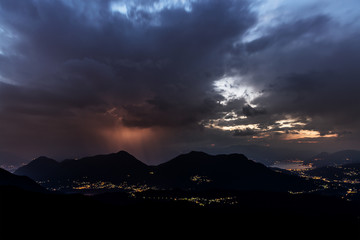 Thunderstorm over mountains at the horizon