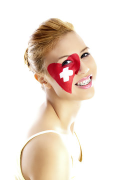smiling girl with swiss flag painted on her face