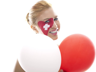 smiling girl with swiss flag painted on her face