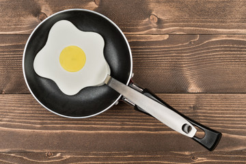 Egg shaped spatula into a frying pan, top view