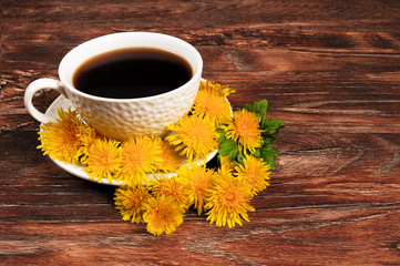 Coffee mug surrounded by dandelions on a wooden background.