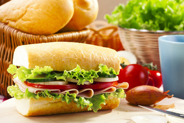 Breakfast sandwich with vegetables and a cup of hot cocoa.