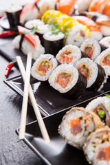 Delicious sushi pieces served on black stone