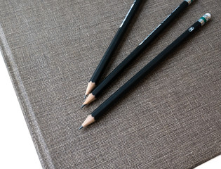 Three pencils on book