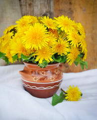Bouquet of dandelions in a ceramic jug