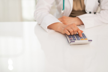 Fototapeta premium Closeup on medical doctor woman using calculator
