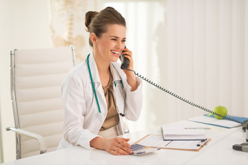 Happy medical doctor woman talking phone