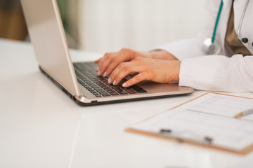 Closeup on medical doctor woman working on laptop