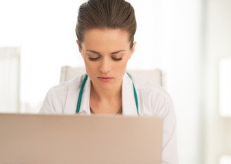 Medical doctor woman working on laptop
