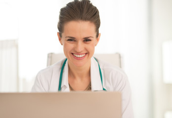 Portrait of smiling medical doctor woman using laptop