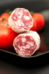 salami on plate with tomatoes close up