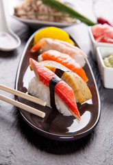 Delicious sushi pieces served on black stone