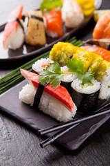 Delicious sushi pieces served on black stone