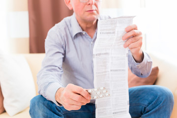 Senior liest zuhause Medikamenten Beipackzettel 