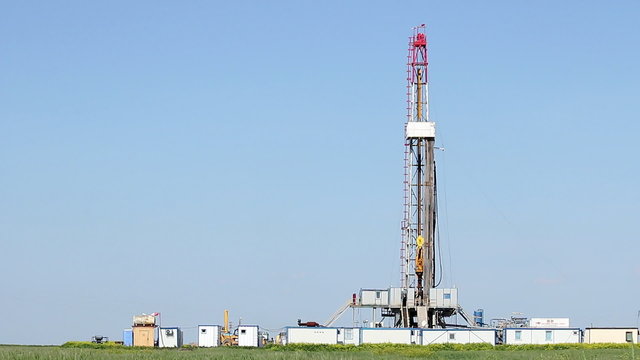 oil drilling rig on green field