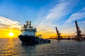 Obraz premium Big tugboat in a harbor at sunrise.