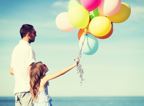 father and daughter with colorful balloons
