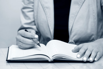 Business woman writing in notebook