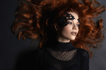 beautiful red-haired girl lace makeup in the dark