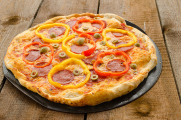 Italian pizza with paprika, salami and olives