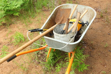 wheelbarrow with building and garden supplies in the yard