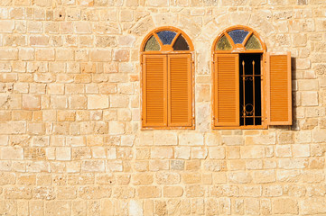 Two shuttered windows in stone wall of  Jaffa mosque. Israel.