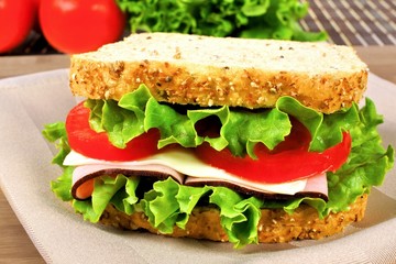 Sandwich with meat, tomato, lettuce and cheese