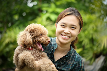 Asian girl play with brown color poodle