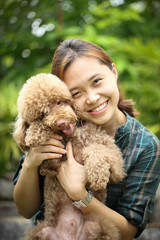 Asian girl play with brown color poodle