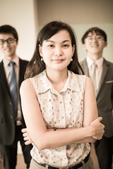 Happy business team with arms crossed at the office