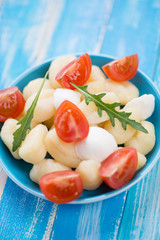 Gnocchi with sliced mozzarella, red cherry tomatoes and arugula