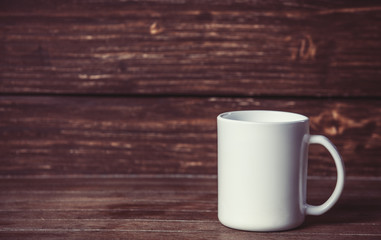 Cup on wooden table and with wood on background