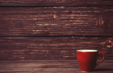 Cup on wooden table and with wood on background
