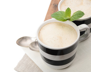 2 cups of coffee with mint on a napkin